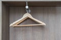 Fragment of wardrobe from inside. Empty light wooden clothes hangers hang from metal rod. Home storage system Royalty Free Stock Photo