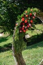 Fragment of wedding arch for a ceremony on green background. Wedding decorations with beautiful flowers