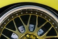 Fragment of the wheel sports cars, thin-profile tires, brake discs, beautiful spokes painted in gold. Royalty Free Stock Photo