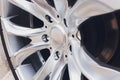 Fragment of white modern car with wheel on steel disc, closeup photo. Royalty Free Stock Photo