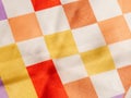 Fragment of white silk fabric with geometric pattern in the form of multicolored squares Royalty Free Stock Photo