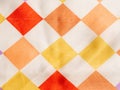 Fragment of white silk fabric with geometric pattern in the form of multicolored squares arranged in staggered order Royalty Free Stock Photo