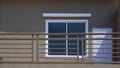 Fragment of white wooden door and glass window on brown cement wall with balcony on external view of house building, exterior