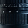 Fragment of a wide angle zoom lens for a modern SLR camera. The set of distance values is indicated by white numbers on the black Royalty Free Stock Photo