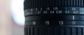 Fragment of a wide angle zoom lens for a modern SLR camera. The set of distance values is indicated by white numbers on the black Royalty Free Stock Photo