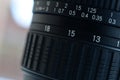 Fragment of a wide angle zoom lens for a modern SLR camera. The set of distance values is indicated by white numbers on the black Royalty Free Stock Photo