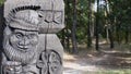 Fragment of a wooden carved gateway with good forest gnomes in a wood Park.