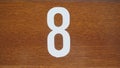 Fragment of a wooden door with a house number eight Royalty Free Stock Photo