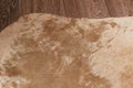 A fragment of a worn beige hide laid on the laminate