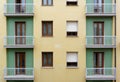 Fragment of yellow and green tiled facade building with balconies