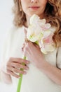 A fragmentary portrait of a cute European girl in a white dress against a light background.