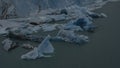 Fragments of blue ice and icebergs float in turquoise water. Royalty Free Stock Photo