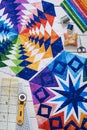 Fragments of quilt, accessories for patchwork, top view on a white wooden surface
