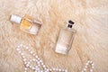 Fragrance bottles with necklace at sheepskin fur. glamour concept. flat lay