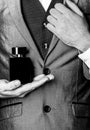 Fragrance smell. Men perfumes. Fashion cologne bottle. Man holding up bottle of perfume. Men perfume in the hand on suit Royalty Free Stock Photo