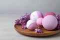 Fragrant bath bombs and lilac flowers on wooden table, space for text