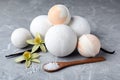 Fragrant bath bombs, sea salt, vanilla sticks and flowers on grey marble table