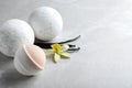 Fragrant bath bombs, vanilla sticks and flower on light grey table. Space for text