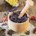 Fragrant dried healing herbs for therapy and spicy spices. On the table in a mortar purple basil, tansy, pepper, chili and Royalty Free Stock Photo