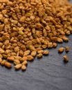 Fragrant grains of fenugreek on a rustic background