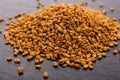 Fragrant grains of fenugreek on a rustic background