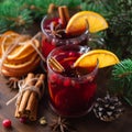 Fragrant, hot punch or mulled wine for Christmas in a glass on a wooden board and branches of a Christmas tree on the background. Royalty Free Stock Photo