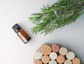 fragrant medicinal evergreen rosemary on a light background with a transparent glass and a jar of hair oil