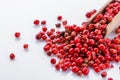 Fragrant pink peppercorns on white acrylic background