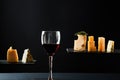 Fragrant red wine in glass beside sliced fresh cheese of different sorts Royalty Free Stock Photo