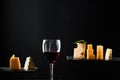 Fragrant red wine in glass beside sliced fresh cheese of different sorts Royalty Free Stock Photo