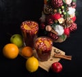Fragrant spicy traditional drink in a glass goblet, mulled wine, with a Christmas tree, spices and fresh fruits Royalty Free Stock Photo