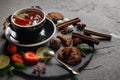 Fragrant tea in a black cup on a black plate with biscuits, lemon, cinnamon and fruits Royalty Free Stock Photo