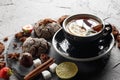 Fragrant tea in a black cup on a black plate with biscuits, lemon, cinnamon and fruits Royalty Free Stock Photo