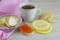 Fragrant tea with lemon and a sandwich with red caviar. Royalty Free Stock Photo