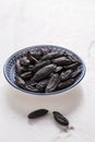 Fragrant tonka beans in small bowl on white background, baking flavored ingredient Royalty Free Stock Photo