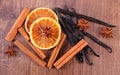 Fragrant vanilla, cinnamon, star anise and dried orange on wooden surface Royalty Free Stock Photo