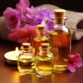 Fragrant yellow massage oil in transparent bottles and pink flowers on the table in the spa salon