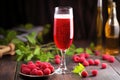 framboise lambic beer in a flute glass, with raspberries around