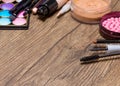 Frame of basic makeup products on wooden surface Royalty Free Stock Photo