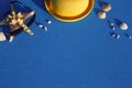 Frame with beach accessories on a nautical theme: yellow straw hat, sunglasses, starfish and shells on a blue background. Royalty Free Stock Photo