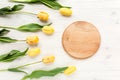 Frame with beautiful yellow tulips isolated on a white, wooden background. lay flat, top view