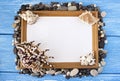 Frame with a blank sheet for inscription on a blue wooden background of gorshkov stones and seashells