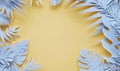 A frame of blue paper tropical leaves on a yellow background Royalty Free Stock Photo