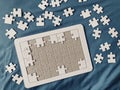 the frame board of an all-white jigsaw puzzle with many puzzle pieces Royalty Free Stock Photo