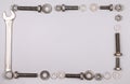 Frame with bolts, nuts, washers and wrench on a gray background Royalty Free Stock Photo