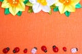 Frame of bright artificial flowers and ladybirds - a multi-colored, background Royalty Free Stock Photo