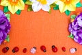 Frame of bright artificial flowers and ladybirds - a multi-colored, background Royalty Free Stock Photo