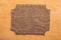 Frame of burlap, lies on a background of wood Royalty Free Stock Photo