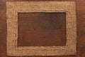 Frame of burlap, lies on a background of wood Royalty Free Stock Photo