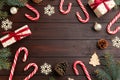 Frame of candy canes, gift boxes and Christmas decor on wooden table. Space for text Royalty Free Stock Photo